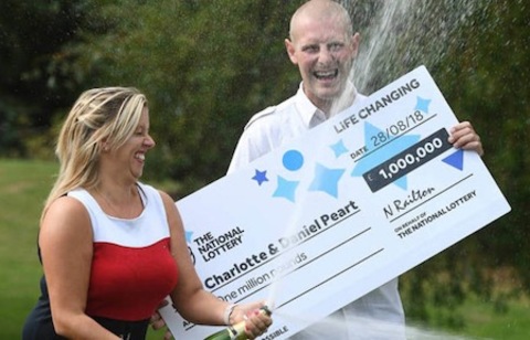 EuroMillions Winners Charlotte and Daniel Peart with Oversized Cheque and Champagne