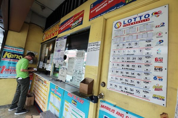 PCSO Lottery Ticket Agent with Customer at Window