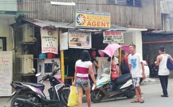 Philippines Authorized Lotto Agent with People and Scooters Outside